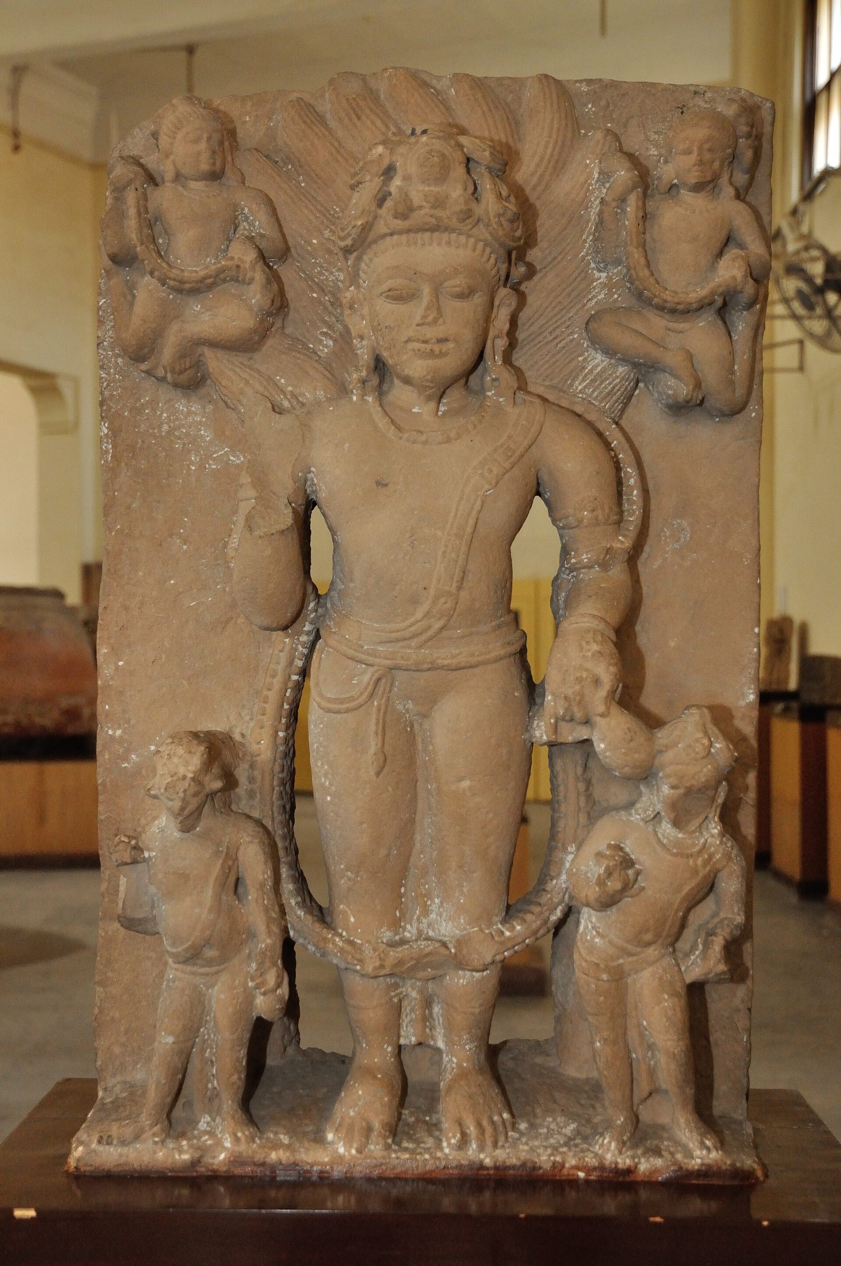 Medieval stone sculpture of the Hindu fire deity Agni with attendant figures.