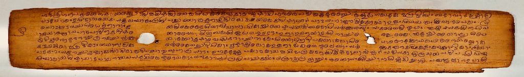 Historic palm-leaf manuscript with handwritten Malayalam script commentary on the Bhagavata Purana.