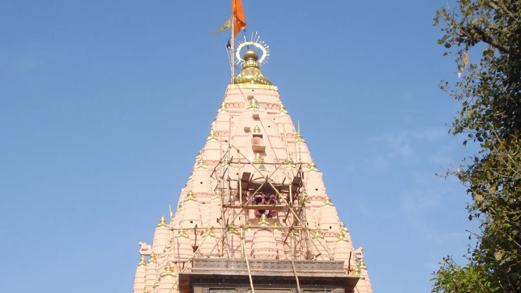 Upper tower of Mahakaleshwar Temple in Ujjain beneath a blue sky.